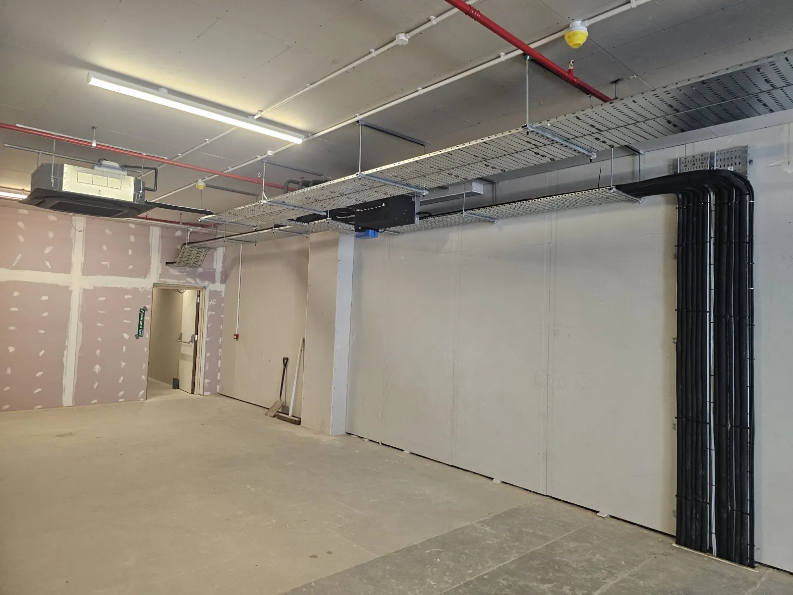 Commercial unit mid fit-out with air conditioning pipework run neatly down the wall
