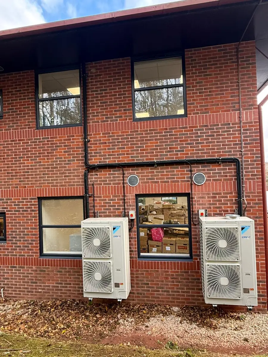 Two Daikin outdoor air conditioning units on the elevation of a brick office building