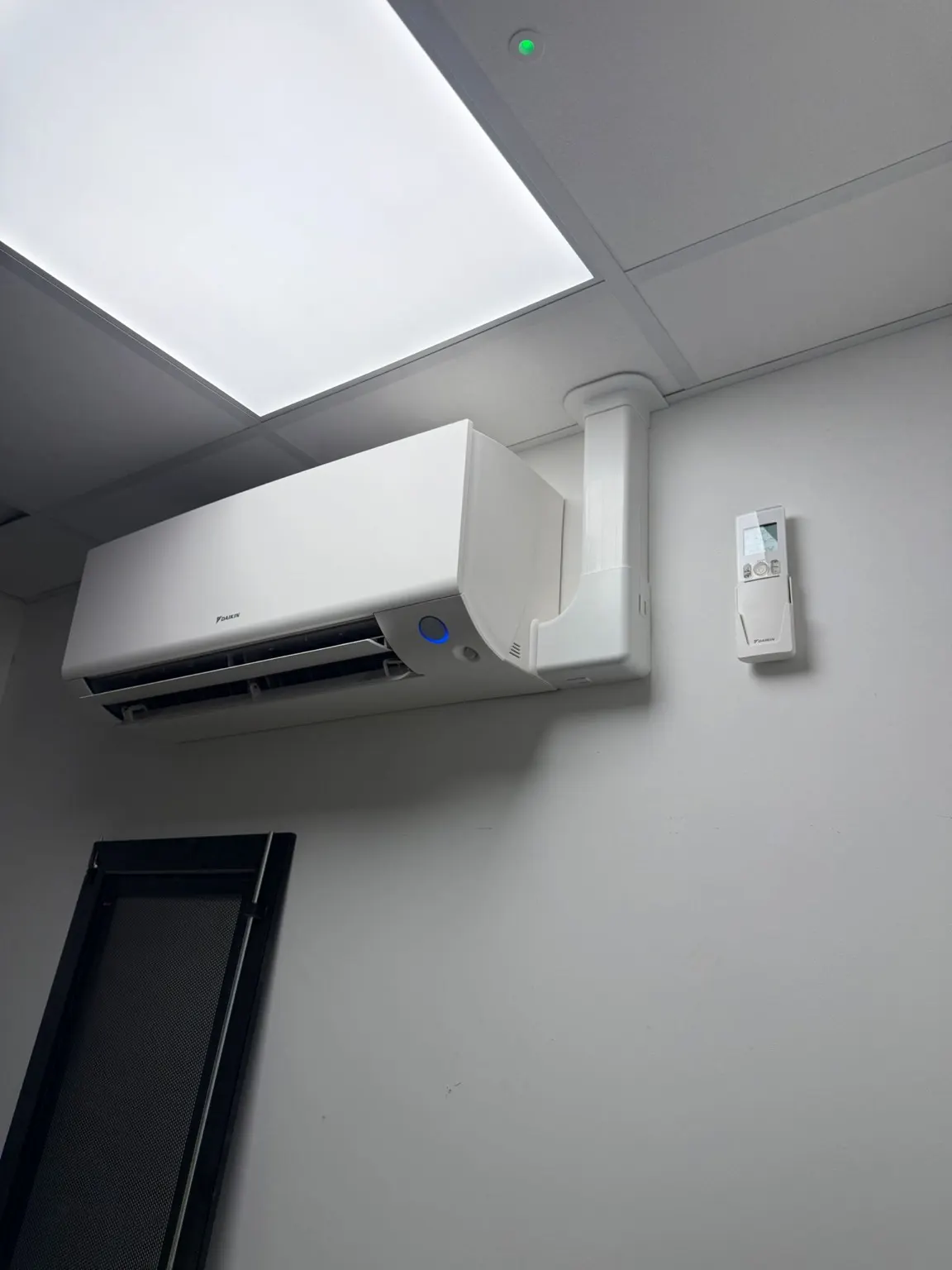 Wall-mounted Daikin indoor air conditioning unit with the pipework neatly boxed in