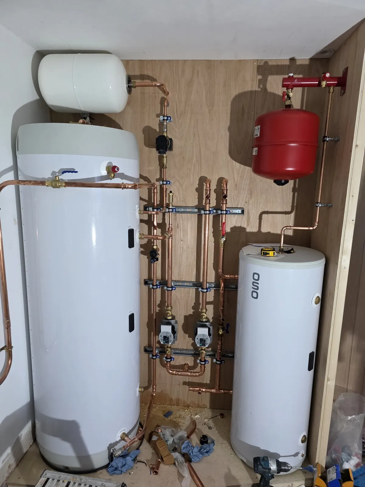 Hot water cylinder and buffer tank fitted into an airing cupboard with copper pipework