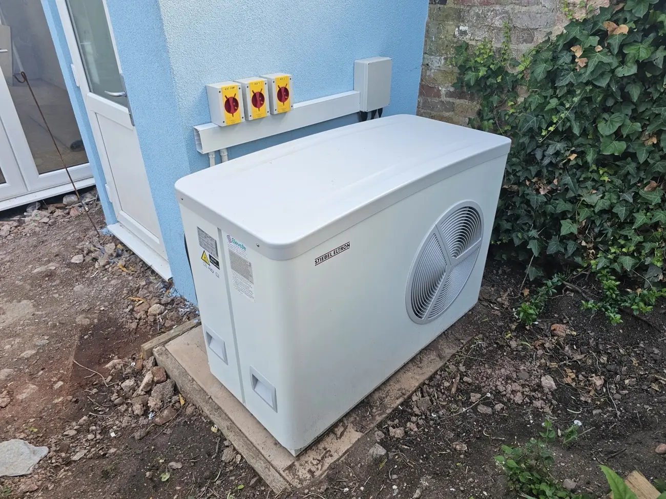 Stiebel Eltron air source heat pump installed on its base outside a house